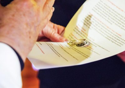 closeup of vicar blessing wedding rings