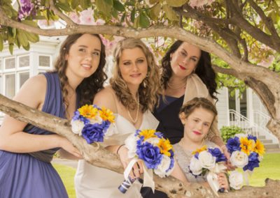 bride & ladies with bouquets under pink rhododendron bushes