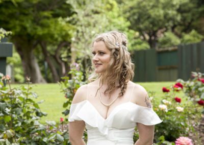 windswept bride outdoors in rosegarden