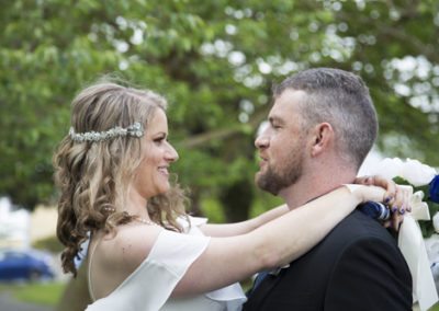 closeup of happy bride & groom embracing outdoors in bush setting