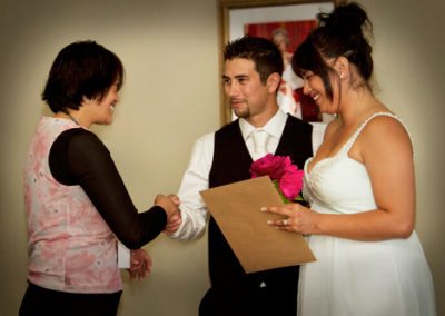 Registry office celebrant shaking hands with Maori bride & groom