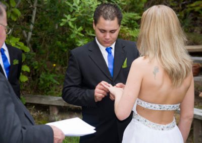 outdoors country wedding groom putting ring on bride's finger