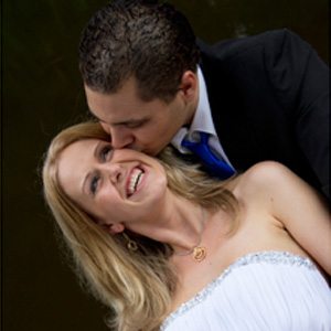 close up romantic groom giving smiling bride romantic kiss on the cheek