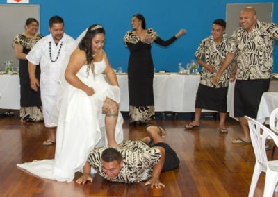 Siva Samoa with bride with her foot on groomsman's back as he lies on floor