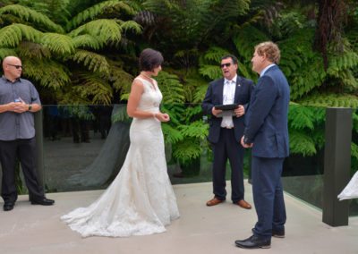 bride & groom with celebrant speaking in native bush setting