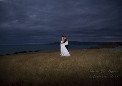 Bride & groom embrace on hilltop at night, Wellington hills behind Pencarrow Lodge wedding