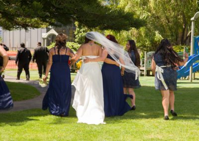Maori bride & bridesmaids walking windswept in park