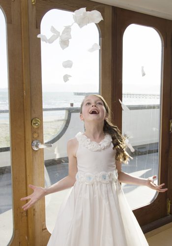 laughing flower girl tossing petals in the air