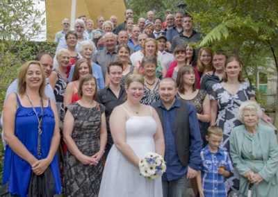 group photo of couple and wedding guests on outdoors steps