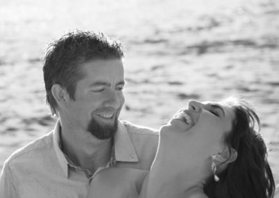 laughing bride with head thrown back and groom smiling at her