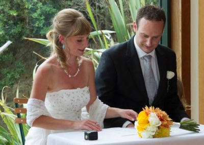bride & groom signing register with nature background