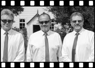 B&W groomsmen outside Wallaceville church