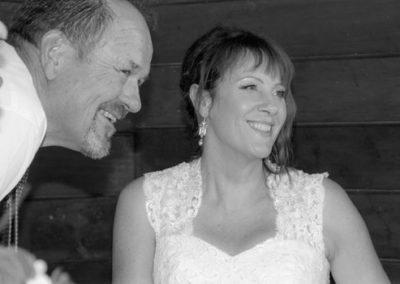B&W bride & groom smiling during wedding ceremony