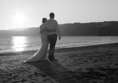 B&W sunset, bride & groom walking away arm in arm Petone beach