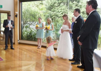 bridal party speeches with little girl looking up at bride, beautiful bushy setting