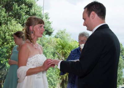 bride & groom exchanging rings closeup, beautiful bushy setting