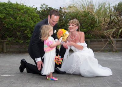 bride & groom with little girl outdoors in windy conditions