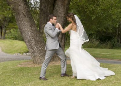 groom romantically kissing bride's hand in country setting