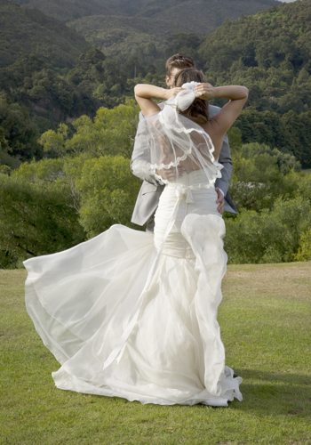 bride & groom wind blown veil & dress in country setting