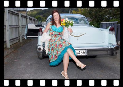 colourful bridesmaid on classic car
