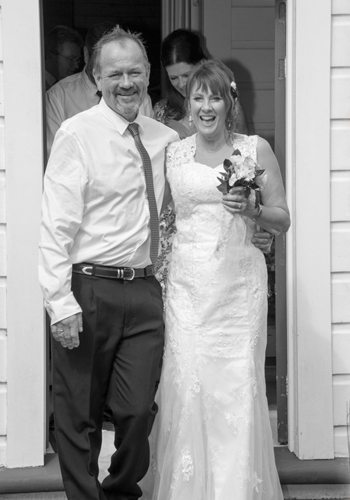 B&W bride & groom coming through doorway of Wallaceville church