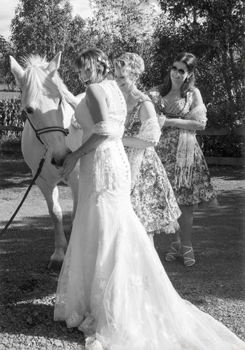 B&W laughing bride & ladies with white horse