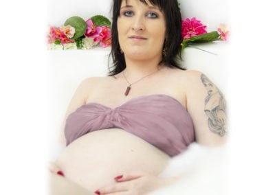 pregnancy maternity pregnant woman in milk bath with pink top and pink flowers