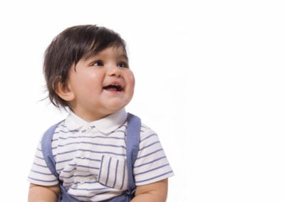 cute boy toddler with stripey top looking up and smiling