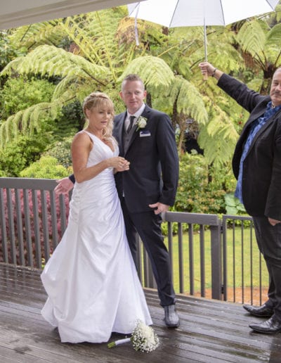 Bride & groom on deck in rain