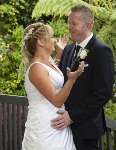 Bride & groom outdoors on deck in rain